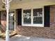 The entryway to this home features a brick facade with white trim and a storm door at 4204 Peachtree Ln., Myrtle Beach, SC 29588