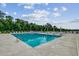Resort style pool with lounge chairs, tables, lush landscaping, and a view of the trees and sky at 439 Kapalua Loop, Little River, SC 29566