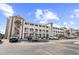 Spacious condominium building with ample parking and lovely landscaping under a beautiful blue sky at 4518 N Planatation Harbour Dr. # G-17, Little River, SC 29566