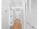Bright, neutral hallway with wood-look floors, white doors, and closet with shell-style knobs at 4518 N Planatation Harbour Dr. # G-17, Little River, SC 29566
