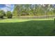 Spacious backyard with lush green grass, a black metal fence, and views of mature trees and a serene pond at 505 Heartland Ct., Murrells Inlet, SC 29576