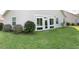 Wide backyard featuring white frame doors, an extended sunroom, and vibrant green lawn at 505 Heartland Ct., Murrells Inlet, SC 29576