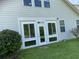 Backyard exterior showcasing white frame doors, an extended sunroom, and vibrant green lawn at 505 Heartland Ct., Murrells Inlet, SC 29576