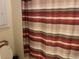 Neutral bathroom with a striped shower curtain and toilet at 505 Heartland Ct., Murrells Inlet, SC 29576