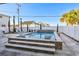 Backyard pool featuring integrated loungers, travertine decking, privacy fencing, and tasteful landscaping at 5203 N Ocean Blvd. N, North Myrtle Beach, SC 29582