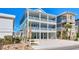 Three-story coastal home with ample parking, a well-manicured lawn, and multiple covered decks at 5203 N Ocean Blvd. N, North Myrtle Beach, SC 29582