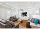Cozy living room with tray ceilings, hardwood floors, neutral furniture, and a large television built into the wall unit at 5203 N Ocean Blvd. N, North Myrtle Beach, SC 29582