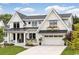 Stunning two-story home boasts a white exterior, black trim, a manicured lawn, and an attached two car garage at 573 Starlit Way, Myrtle Beach, SC 29579
