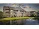 Exterior view of a building overlooking a tranquil pond with a fountain at 5882 Longwood Dr. # 201, Murrells Inlet, SC 29576