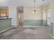Open dining area with a chandelier, wainscoting, and neutral carpet next to the kitchen at 5882 Longwood Dr. # 201, Murrells Inlet, SC 29576