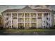 Attractive condo building with a well-kept lawn, multiple stories, balconies, and welcoming front doors at 5882 Longwood Dr. # 201, Murrells Inlet, SC 29576