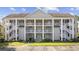 Inviting condo complex featuring multiple stories, white railings, and well-maintained landscaping under a clear sky at 5882 Longwood Dr. # 201, Murrells Inlet, SC 29576