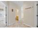 Hallway with tile floors leading to a bathroom and bedroom, showcasing neutral walls and coat hooks at 5882 Longwood Dr. # 201, Murrells Inlet, SC 29576