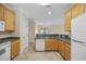 Galley kitchen with appliances, light wood cabinets, and tiled floors, located off a hallway at 5882 Longwood Dr. # 201, Murrells Inlet, SC 29576