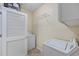 A functional laundry room with appliances and a storage shelf, designed for efficiency and convenience at 5882 Longwood Dr. # 201, Murrells Inlet, SC 29576