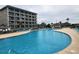 A large pool with a condo building in the background and several lounge chairs on the pool deck at 5905 S Kings Hwy. # 404 A, Myrtle Beach, SC 29575