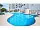 Large, sparkling outdoor swimming pool with sun loungers and building view at 5905 S Kings Hwy. # 404 A, Myrtle Beach, SC 29575