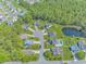 An aerial view highlighting a community with mature trees, a pond, and well-maintained lawns at 6000 Isabel Ct., Myrtle Beach, SC 29579