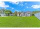 Spacious backyard with lush green grass, an adjacent sunroom, and a white fence, perfect for outdoor enjoyment at 6000 Isabel Ct., Myrtle Beach, SC 29579