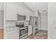 Modern kitchen with stainless steel appliances, white cabinets, and patterned tile flooring at 6000 Isabel Ct., Myrtle Beach, SC 29579