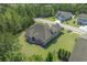 An aerial view showcases the home with a screened porch, lush landscaping, and bordering mature trees at 610 Cocas Dr., Myrtle Beach, SC 29579