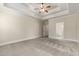 Large bedroom with a tray ceiling, neutral walls, ceiling fan and adjoining bathroom at 610 Cocas Dr., Myrtle Beach, SC 29579