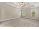 Spacious bedroom with a tray ceiling, neutral carpet, and views to the outside at 610 Cocas Dr., Myrtle Beach, SC 29579
