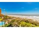 Stunning aerial view of beach and pool area with palm trees at 6804 N Ocean Blvd. # 523, Myrtle Beach, SC 29572