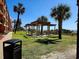 Outdoor picnic area with covered tables, surrounded by palm trees near the beach at 6900 N Ocean Blvd. # 1034, Myrtle Beach, SC 29579