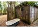 Exterior shot of a rustic cabin with a vintage tub, surrounded by trees and nature at 70 Izard Pl., Georgetown, SC 29440