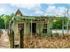 Waterfront cabin with peeling paint and damaged roof, nestled among tall grasses and accessed by a wooden dock at 70 Izard Pl., Georgetown, SC 29440