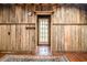 Rustic living room featuring wood-paneled walls, hardwood floors, and a bright entryway with a glass-paned door at 70 Izard Pl., Georgetown, SC 29440