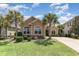 Charming single-story home with well-manicured lawn, vibrant landscaping, and mature palm trees at 7041 Turtle Cove Dr., Myrtle Beach, SC 29579