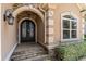 Close-up of the home's arched entry with ornate black double doors and manicured landscaping at 7041 Turtle Cove Dr., Myrtle Beach, SC 29579