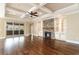 Spacious living room featuring hardwood floors, a stone fireplace, built-in shelving, and coffered ceiling at 7041 Turtle Cove Dr., Myrtle Beach, SC 29579