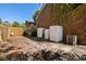 View of the backyard with sheds, a brick house, a wooden fence, and an air conditioning unit at 707 S 26Th Ave. S # L, North Myrtle Beach, SC 29582
