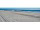 Waves rolling onto an expansive beach under a clear sky; serene coastal scene at 720 N Waccamaw Dr. # 207, Garden City Beach, SC 29576
