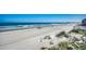 Beautiful beach view showing wide beach, ocean, dunes, and a glimpse of a pier at 720 N Waccamaw Dr. # 207, Garden City Beach, SC 29576