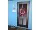 Charming unit entrance door with patriotic wreath, painted blue, and displaying the unit number at 720 N Waccamaw Dr. # 207, Garden City Beach, SC 29576