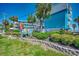 Inviting condo complex with lush landscaping, signage, and an American flag waving in a beautiful blue sky at 720 N Waccamaw Dr. # 207, Garden City Beach, SC 29576