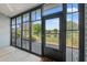 Relaxing sunroom featuring large windows with a scenic view of the pond and well-manicured landscaping at 775 Plantation Dr. # 87, Little River, SC 29566