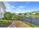 Backyard featuring well-manicured lawn, black aluminum fence, and serene pond at 809 Covelo Ln., Myrtle Beach, SC 29579