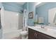Bathroom with shower-tub, brown vanity, framed art and blue walls at 809 Covelo Ln., Myrtle Beach, SC 29579