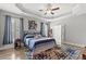 Cozy bedroom featuring tray ceilings, plantation shutters, ceiling fan, and ensuite bathroom at 809 Covelo Ln., Myrtle Beach, SC 29579
