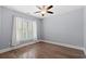 Empty bedroom with wood floors, ceiling fan, window with white shutters, and neutral walls at 809 Covelo Ln., Myrtle Beach, SC 29579