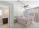 Comfortable bedroom with an en suite bathroom, ceiling fan and large window with shutters at 809 Covelo Ln., Myrtle Beach, SC 29579