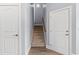 Hallway with carpeted stairs and wood-look tile flooring and two white doors at 809 Covelo Ln., Myrtle Beach, SC 29579