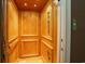 Home elevator with wood paneled walls and wood floor at 9 Gasparilla Circle, Murrells Inlet, SC 29576