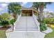 Grand staircase ascends to covered porch and entrance, surrounded by palm trees and lush landscaping at 9 Gasparilla Circle, Murrells Inlet, SC 29576