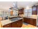 Open kitchen features granite counters, stainless hood, island cooktop and seating at counter to a sunny dining area at 9 Gasparilla Circle, Murrells Inlet, SC 29576